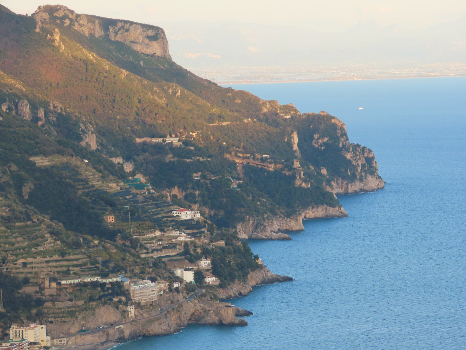 Cliffs and terraced hillsides falling to the sea along the Amalfi Coast at sunset