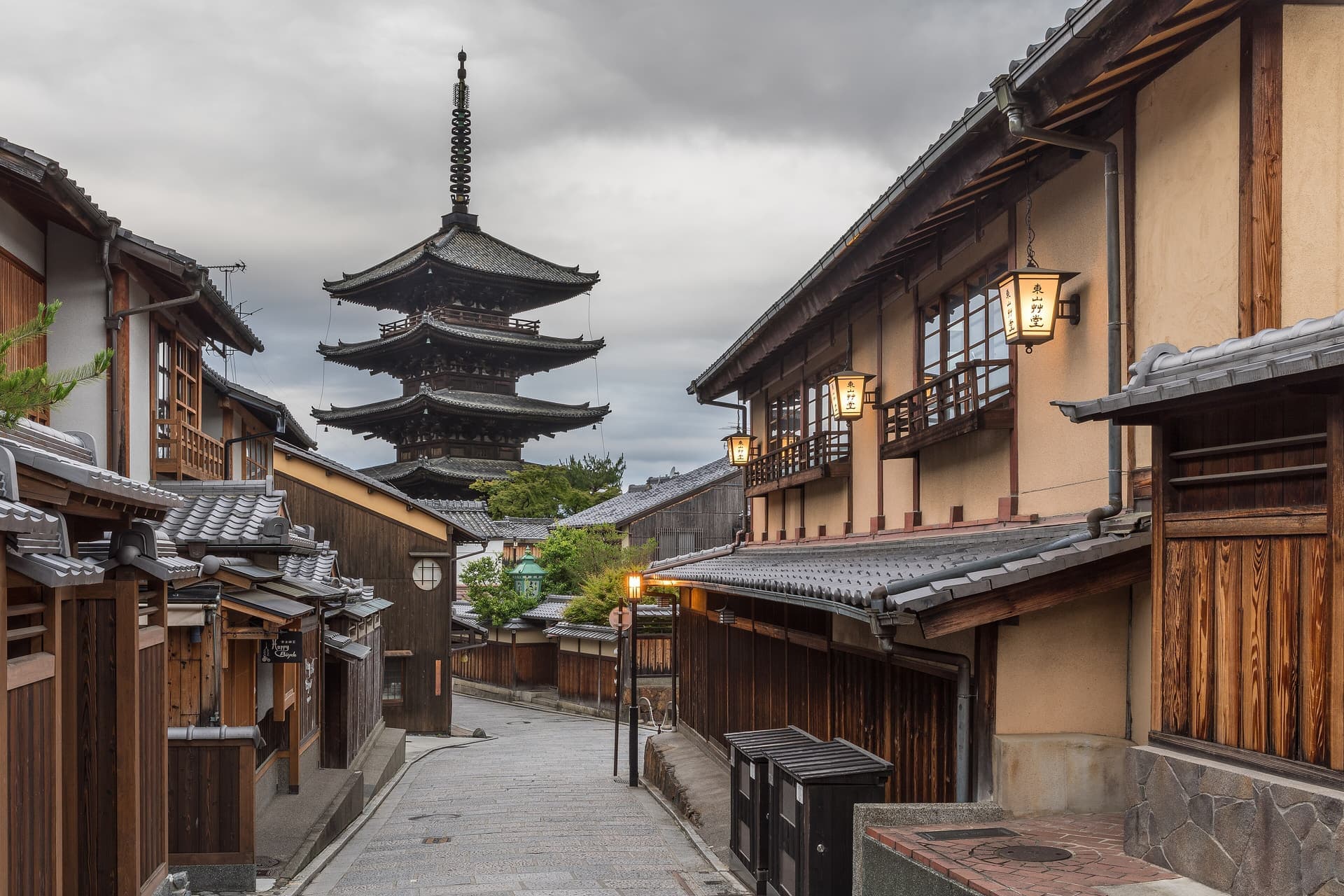 A quiet lane in Kyoto in the early morning, with street lanterns and the five-story pagoda of Yasaka in the distance